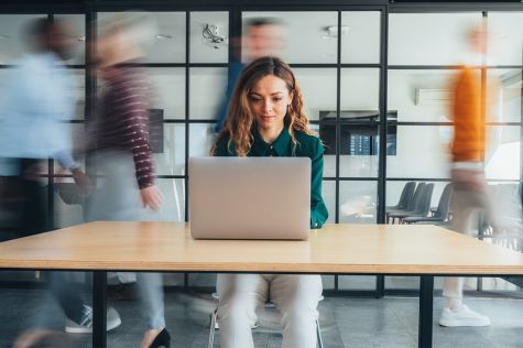 Foto: Frau arbeitet auf einem Laptop an einem Tisch